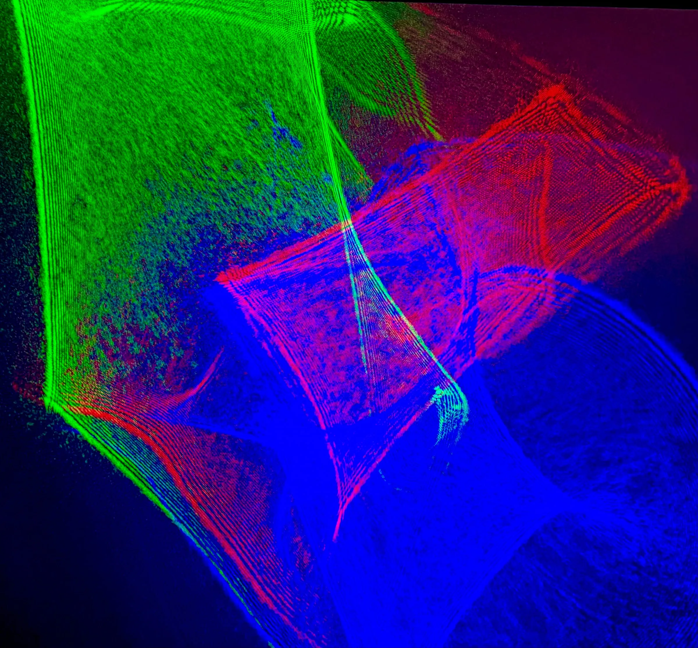 Flowing ribbons of red, green, and blue laser light forming an abstract lumia composition.