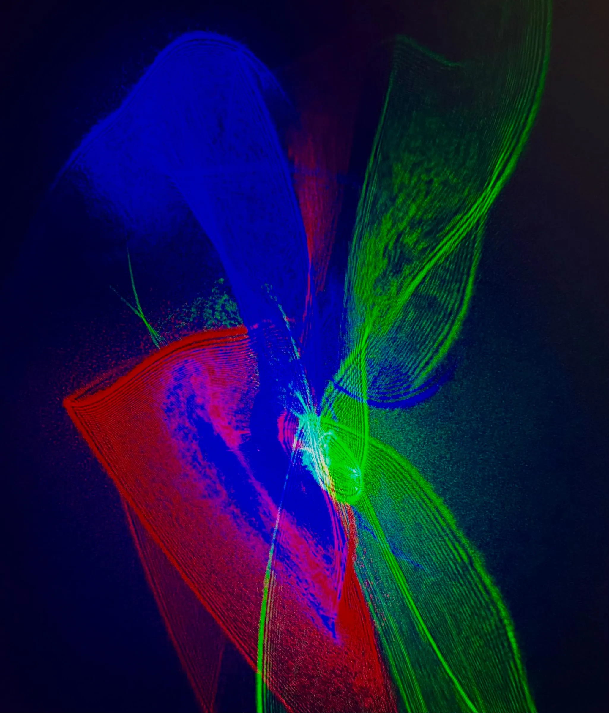 An abstract composition of red, green, and blue laser light.