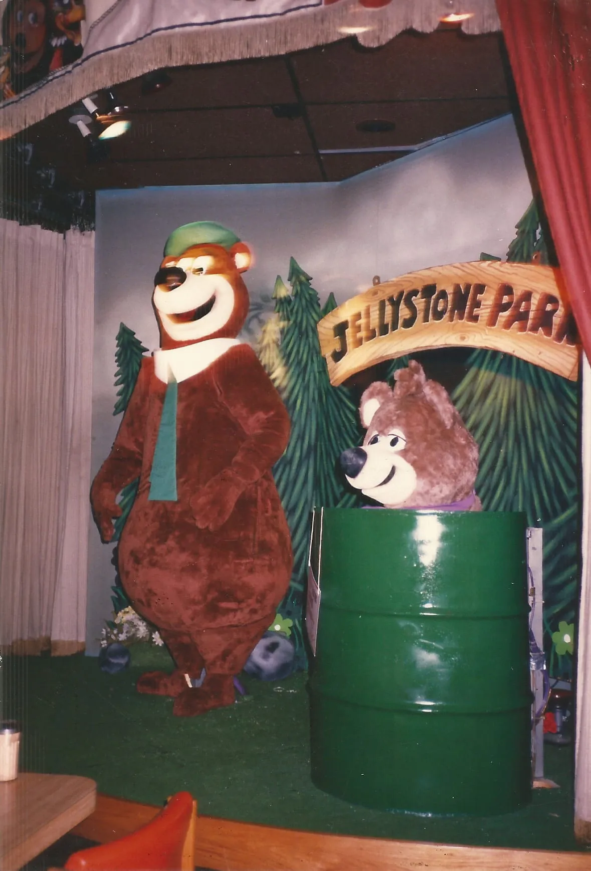 The Yogi Bear animatronic show at ShowBiz Pizza Place — Yogi in his green hat and tie beside Boo-Boo, on the Jellystone Park stage.